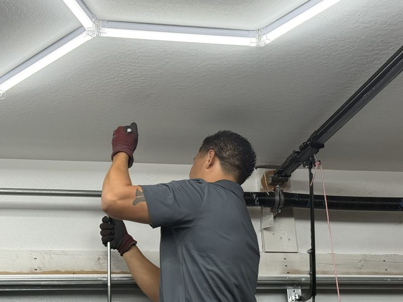 Eric working on a garage door torsion spring above the door