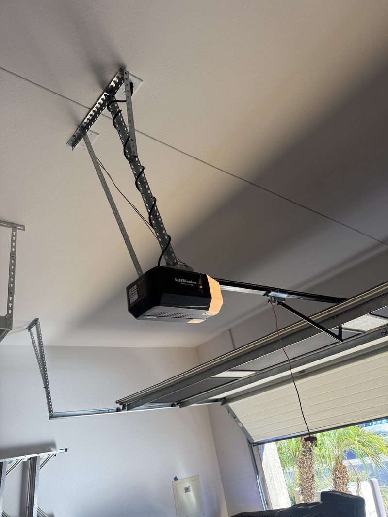 A new LiftMaster belt-drive garage door opener mounted to the ceiling with its light on